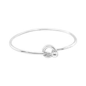 May include: A silver bangle bracelet with a knot design. The knot is a simple circle with a small ball at the end.