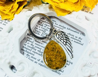 Memory flower key chain with angel wing charm. Made with dried flowers. Ask about using cremations, hair or fabric.