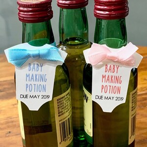 May include: Three miniature liquor bottles with personalized labels that say "Baby Making Potion" and "Due May 2019". One bottle has a blue bow and the other has a pink bow.