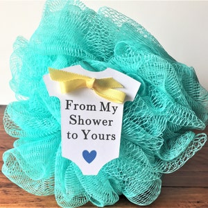 May include: A turquoise bath pouf with a white onesie-shaped tag that says "From My Shower to Yours" with a blue heart.