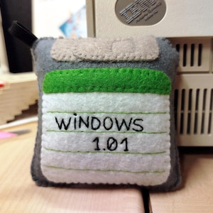 Diskettprydnad - Windows 1.01-etikett på en grå diskett, 1980-talet, Handgjord filtleksak, Datordisk, Heminredning, nördgåva