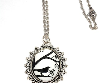 Collier argenté, pendentif cage a oiseaux noir sur blanc