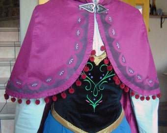 May include: A purple and blue dress with a black bodice and a white fur collar. The dress has a gold trim and a silver snowflake brooch. The dress is a costume for a popular animated character.