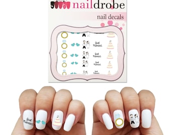 May include: Nail decals with a wedding theme. The decals feature a bride and groom, wedding rings, a wedding cake, and the text "Just Married".
