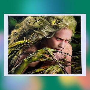 May include: A woman with long blonde hair is surrounded by green branches and insects. Her face is painted with green makeup and she has a serious expression. The image is a close-up of her face and upper body.