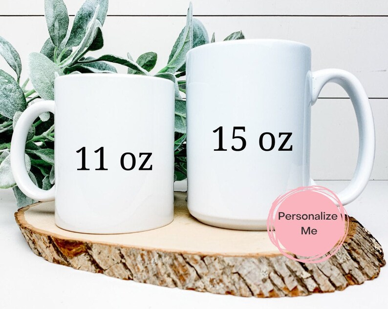 K&ouml;nnte beinhalten: Zwei wei&szlig;e Keramikbecher mit schwarzem Text. Der Becher links zeigt "11 oz" und der Becher rechts zeigt "15 oz".