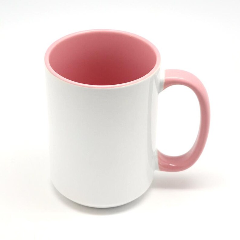 Pode incluir: Uma caneca de cer&acirc;mica branca com interior rosa e al&ccedil;a rosa. A caneca est&aacute; em branco e pronta para ser personalizada.