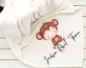 Könnte beinhalten: Weiße Babydecke mit einer braunen Affenillustration und dem Namen "Jackson Robert Thorne" in schwarzer Kursivschrift.