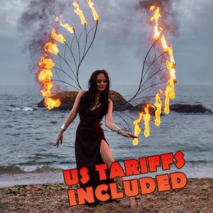 May include: A dark maroon sleeveless dress with a high side slit worn with a large, wing-shaped metal apparatus featuring multiple lit flames extending upwards and outwards. The text US TARIFFS INCLUDED is displayed in bold orange letters.