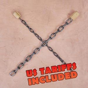 Op de afbeelding: Een paar metalen kettingen gekruist in een X-vorm, elk met een cilindrische beige lont aan één uiteinde. De tekst US TARIFFS INCLUDED is gedrukt in dikke oranje letters met een zwarte omlijning onderaan de afbeelding.