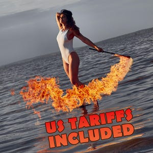 May include: A person wearing a white one-piece swimsuit standing in water while holding a flaming torch that creates a trail of fire. The image includes the orange text US TARIFFS INCLUDED at the bottom, set against a backdrop of open water.