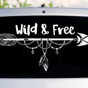May include: White vinyl decal with a black background featuring an arrow with feathers and beads, and the text "Wild & Free".
