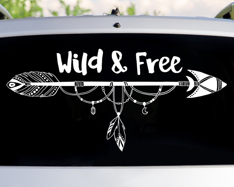 May include: White vinyl decal with a black background featuring an arrow with feathers and beads, and the text "Wild & Free".