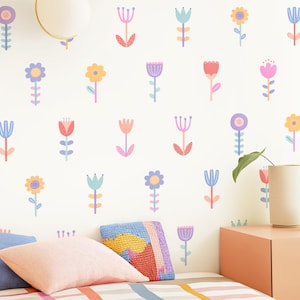 May include: A wall decal set featuring a repeating pattern of stylised flowers in pastel shades of pink, yellow, blue, and purple. Each individual flower has a simple stem and leaf design, arranged in a grid-like layout across a white surface.