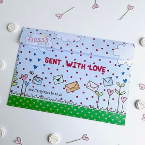 May include: A blue and white envelope with red polka dots and a green border. The envelope has a drawing of flowers, bees, and envelopes with the text "Flossy Teacake" and "Sent with Love" on it. The website address "www.flossyteacake.co.uk" is printed on the envelope.