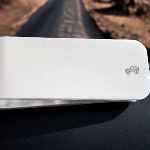 Peut inclure: Porte-monnaie en cuir blanc avec une petite image grav&eacute;e d'une Jeep.