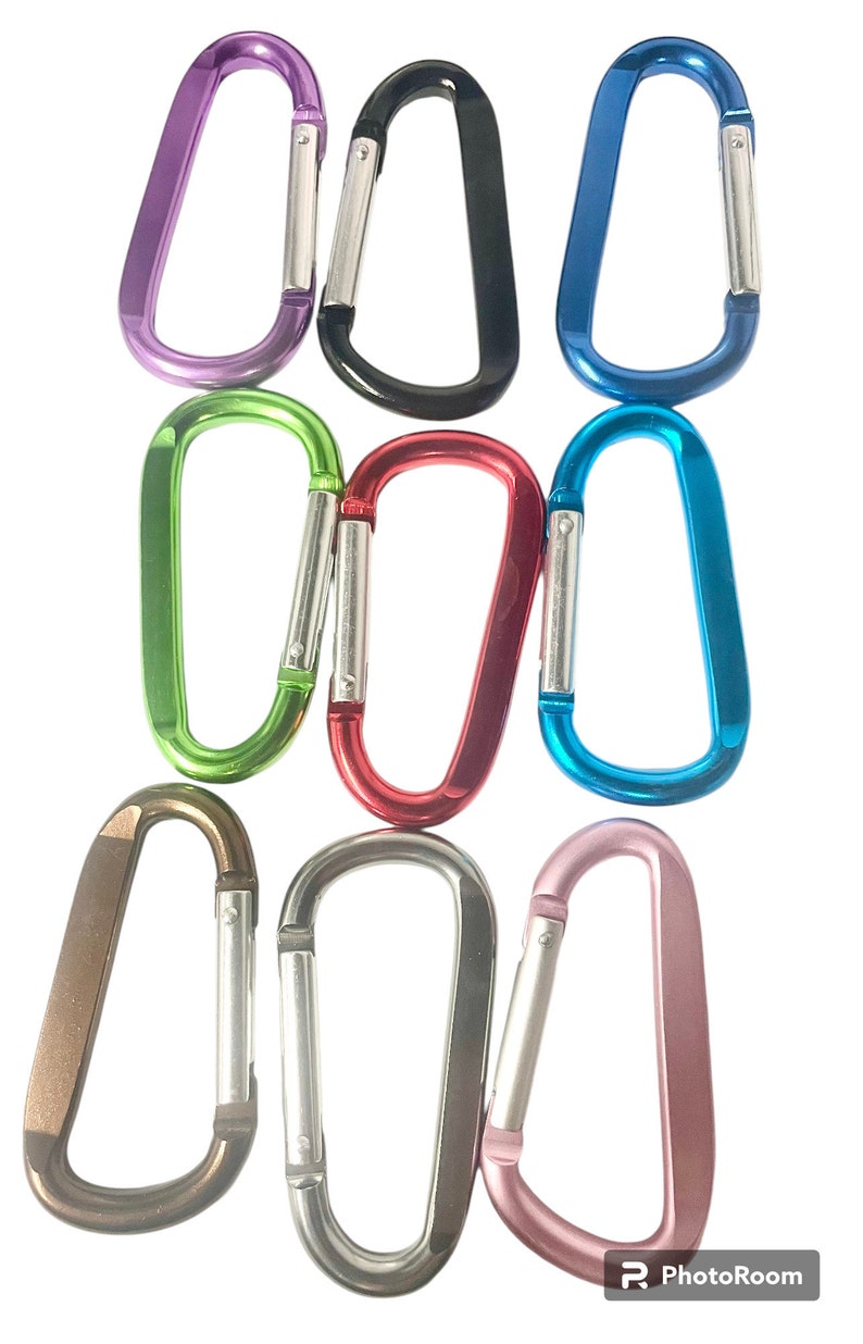 May include: Assortment of ten colorful metal carabiner clips. The clips are in various colors, including purple, black, blue, green, red, silver, and brown.