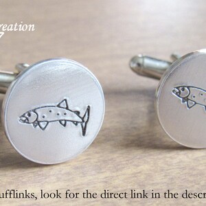 May include: A pair of silver cufflinks, each featuring a detailed outline of a fish.