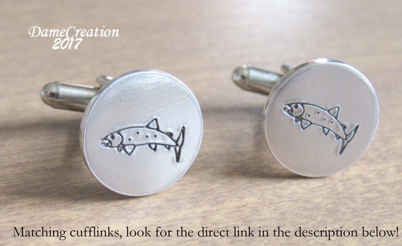 May include: A pair of silver cufflinks, each featuring a detailed outline of a fish.