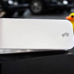 Peut inclure: Pince &agrave; billets en argent avec une petite image grav&eacute;e d'une jeep.