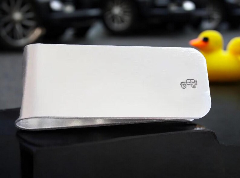 Peut inclure: Pince &agrave; billets en argent avec une petite image grav&eacute;e d'une jeep.