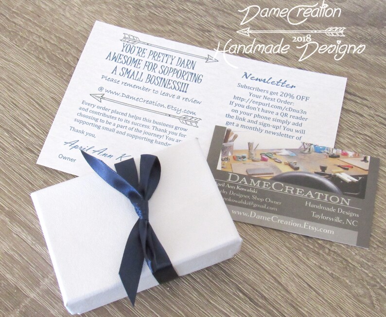 Peut inclure: Une bo&icirc;te cadeau blanche nou&eacute;e d'un ruban bleu marine. La bo&icirc;te est pos&eacute;e sur une surface en bois. Une carte blanche avec du texte noir indique "You're pretty darn awesome for supporting a small business!!!" et "Please remember to leave a review @www.DameCreation.Etsy.com". Une carte blanche avec du texte noir indique "DameCreation 2018 Handmade Designs Newsletter Subscribers get 20% OFF Your Next Order: http://eepurl.com/cDnu3n If you don't have a QR reader on your phone simply add the link and sign-up! You will get a monthly newsletter of". Une carte de visite blanche avec du texte noir indique "DAMECREATION Ann Kowalski Jewelry Designer, Shop Owner akowalski@gmail.com www.DameCreation.Etsy.com Handmade Designs Taylorsville, NC".