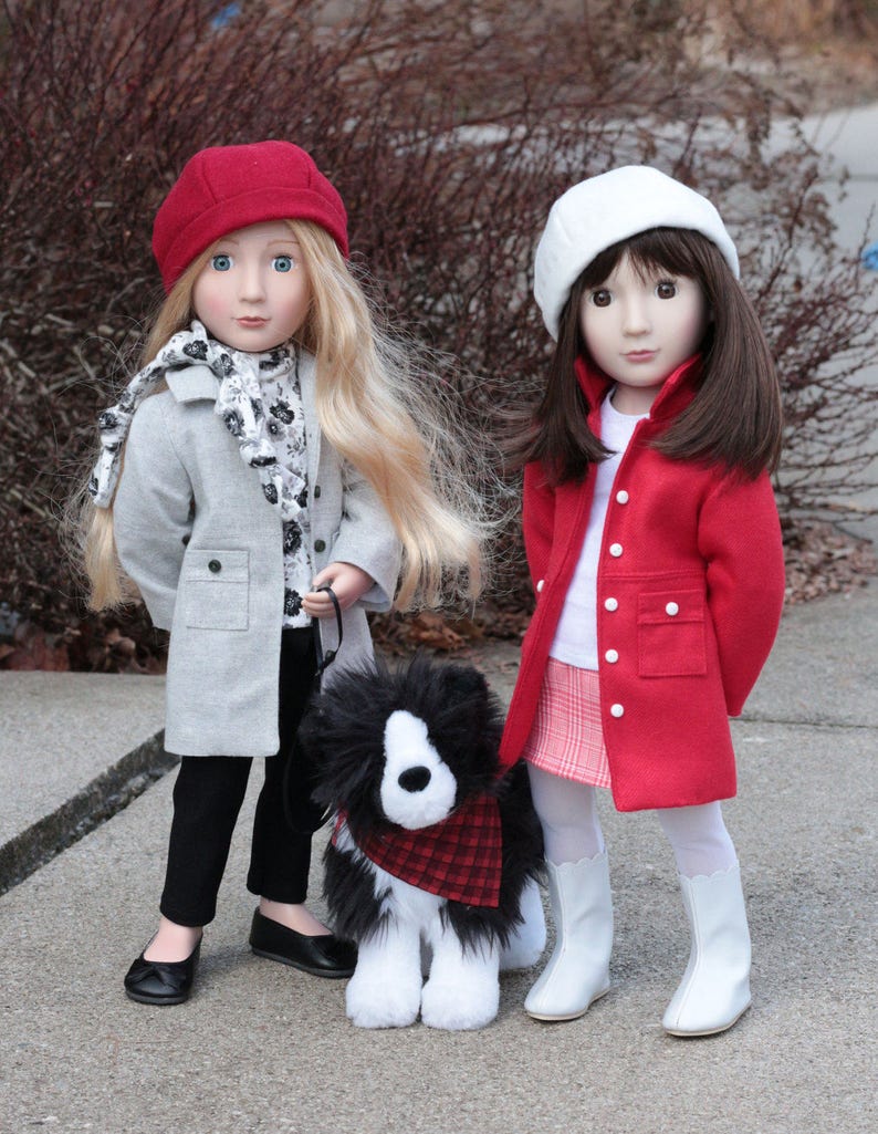 Pode incluir: Duas bonecas vestindo roupas de inverno e um c&atilde;o preto e branco com uma bandana xadrez vermelha e preta. A boneca &agrave; esquerda est&aacute; vestindo um gorro vermelho, um casaco cinza, cal&ccedil;as pretas e sapatos pretos. A boneca &agrave; direita est&aacute; vestindo um gorro branco, um casaco vermelho, uma camisa branca, uma saia xadrez vermelha e branca e botas brancas.