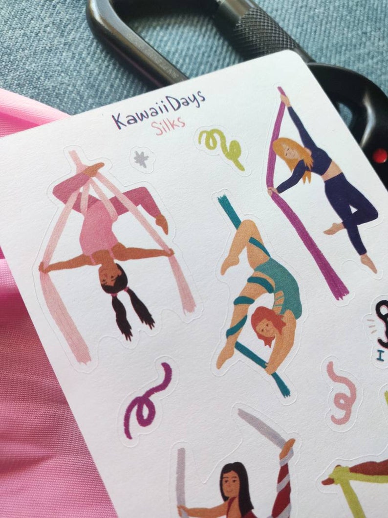 Pode incluir: Uma folha de adesivos com ilustra&ccedil;&otilde;es de pessoas realizando acrobacias a&eacute;reas em tecidos. Os adesivos est&atilde;o em um fundo branco e apresentam o texto "Kawaii Days Silks".