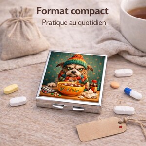 May include: A silver pill box with a colorful illustration of a dog wearing a hat and scarf, with the text "Val&eacute;rie" on a bowl. The image is surrounded by pills, a small bottle, and a tag. The text "Format compact Pratique au quotidien" is at the top.