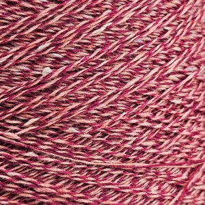 Peut inclure: Gros plan sur une pelote de fil de couleur rose et beige. Le fil a une texture légèrement mouchetée.