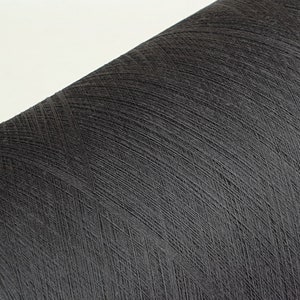 May include: A close-up of a spool of black thread.