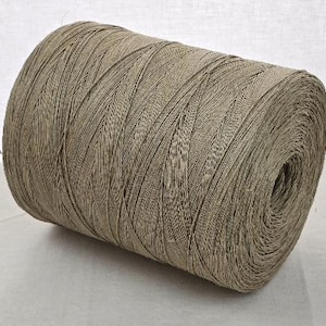 Peut inclure: Une grosse bobine de fil beige. Le fil est étroitement enroulé, présentant un aspect texturé et tissé. La bobine est cylindrique, avec le fil enroulé en couches diagonales. Idéal pour divers projets de bricolage.
