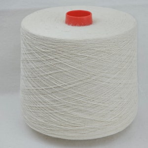May include: A white spool of thread with a red plastic top.