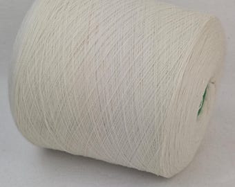 May include: A white skein of yarn wound on a cardboard spool.