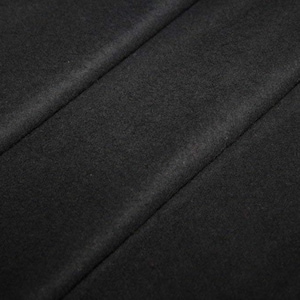 Può includere: Primo piano di un tessuto nero con una superficie liscia e testurizzata. Il tessuto è piegato in modo da creare linee diagonali.
