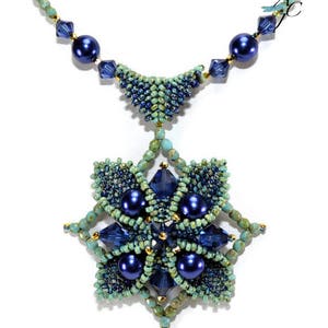 May include: A blue and green beaded necklace with a star-shaped pendant. The pendant is made of blue and green beads and has a gold accent in the center. The necklace is accented with blue pearls.