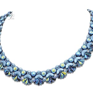 Könnte beinhalten: Eine blaue Perlenkette mit einem mehrschichtigen Design. Die Halskette hat eine gebogene Form mit schillernden Akzenten und einer Vielzahl von Perlen in verschiedenen Größen und Formen. Die Halskette wird auf weißem Hintergrund präsentiert.