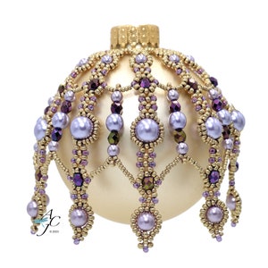 May include: A gold Christmas ornament with a beaded design featuring purple and gold beads. The ornament has a pearl-like finish and a beaded crown.