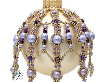 Könnte beinhalten: Ein goldener Weihnachtsbaumschmuck mit einem Perlenmuster aus violetten und goldenen Perlen. Der Schmuck hat eine perlmuttartige Oberfläche und eine Perlenkrone.