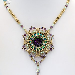 May include: A gold necklace with a large, ornate pendant featuring a purple and green gemstone surrounded by smaller beads. The pendant is in the shape of a flower.