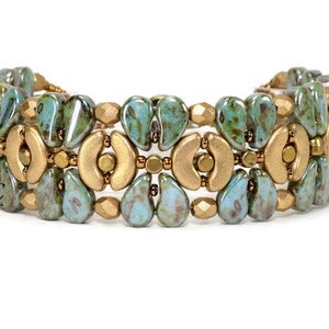 May include: A multi-strand bracelet with teal and gold beads. The bracelet is made with a repeating pattern of teardrop-shaped beads and half-circle beads.