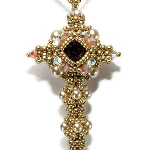 May include: Gold-toned beaded cross pendant necklace. The cross features a central dark red square gem, surrounded by gold beads, iridescent crystals, and faux pearls. The chain is a delicate gold color.