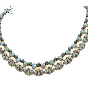 May include: A beaded necklace featuring a repeating pattern of light blue, cream, and bronze-colored beads. The necklace has a curved shape and is displayed against a white background. The text "AC © 2022" is in the upper left corner.