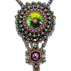 May include: A beaded necklace with a large green crystal pendant. The pendant is surrounded by smaller beads in shades of green, brown, and purple. The necklace is made with a variety of beads, including seed beads, bugle beads, and pearls.