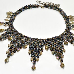 May include: A beaded necklace with a geometric design and dangling crystal accents. The necklace is made of small, iridescent beads in shades of brown, gold, and black.