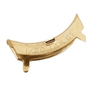 May include: A curved gold-toned metal jewelry finding with two small prongs extending from the bottom edge. The surface is stamped with the text 1/20 14K GF, indicating the material composition of the gold-filled component.