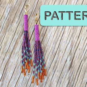 May include: A pair of long, beaded earrings with a pink, purple, and orange color scheme. The earrings are hanging from gold hooks and are on a wooden surface. The word "PATTERN" is written in black on a light blue background.