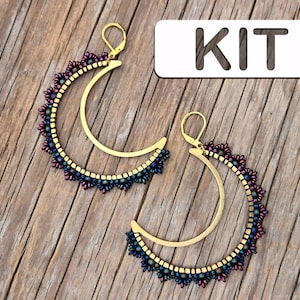 May include: Gold-coloured crescent moon earrings with a beaded edge in purple, blue, and gold. The earrings have a lever-back closure. The word "KIT" is printed on a white rectangle.