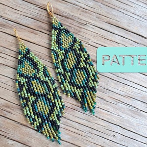 May include: A pair of long, beaded earrings with a black, green and blue geometric pattern. The earrings are hanging from gold hooks.