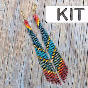 Peut inclure: Une paire de longues boucles d'oreilles perlées avec un design coloré. Les boucles d'oreilles présentent un dégradé de couleurs, dont le rouge, l'orange, le jaune, le bleu et le vert. Les boucles d'oreilles ont des crochets d'oreilles dorés et sont présentées sur une surface en bois. Le mot "KIT" est dans l'image.